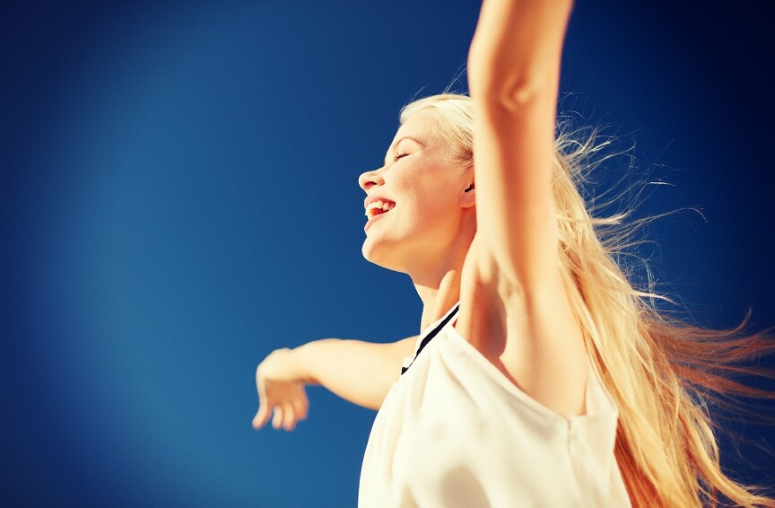 Woman smiling with arms raised